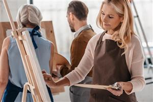 Group of adults painting on canvas.